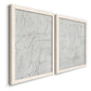 Angled view of a set of two white barnwood framed canvas prints featuring two minimalist script abstracts featuring faint looping handwriting across pale gray grounds.