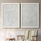 Set of two white barnwood framed canvas prints depicting two minimalist script abstracts featuring faint looping handwriting across pale gray grounds above a sideboard in a cozy sitting room.
