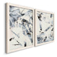 Angled view of a set of two white barnwood framed canvas prints featuring two high-contrast gestural abstracts featuring angular black and gray brush fragments on white.