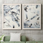 Set of two white barnwood framed canvas prints depicting a coordinated art pair of angular black and gray brush fragments on white rendered as high-contrast gestural abstracts above a sofa in a modern living room.