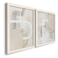 Angled view of a set of two white barnwood framed canvas prints featuring two neutral geometric abstracts with overlapping rounded forms white lines and soft beige gray textures.