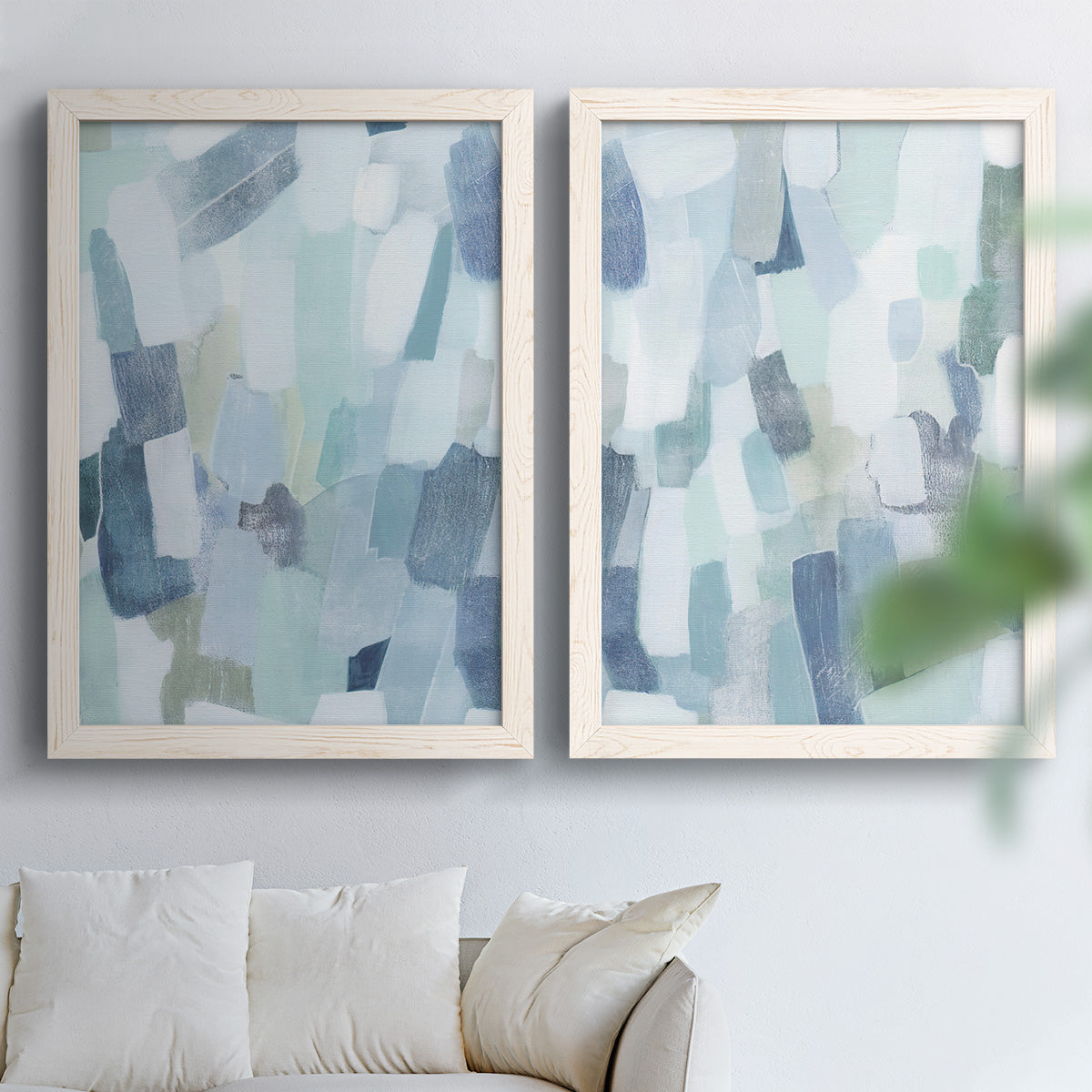 Set of two white barnwood framed canvas prints depicting overlapping rectangular marks and softly weathered paint arranged across two complementary compositions above a sofa in a bright living space.