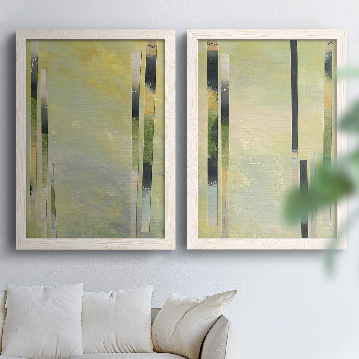 Set of two white barnwood framed canvas prints depicting slender rectangular elements, pale yellow fields, and subtle layered texture arranged across two complementary compositions above a sofa in a bright living space.