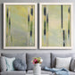 Set of two white barnwood framed canvas prints depicting paired minimalist architectural abstracts with slender rectangular elements, pale yellow fields, and subtle layered texture above a sofa in a contemporary living room.