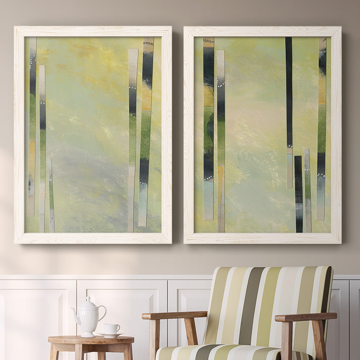 Set of two white barnwood framed canvas prints depicting two minimalist architectural abstracts featuring vertical black gray and olive bars above a sideboard in a cozy sitting room.