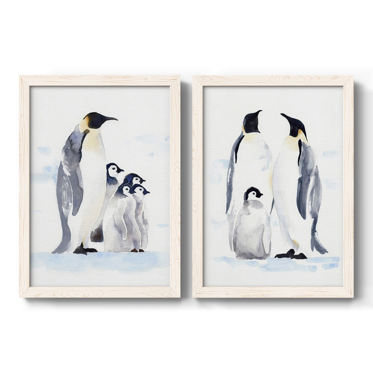 Set of two white barnwood framed canvas prints featuring two soft watercolor wildlife illustrations featuring adult emperor penguins with fluffy chicks.