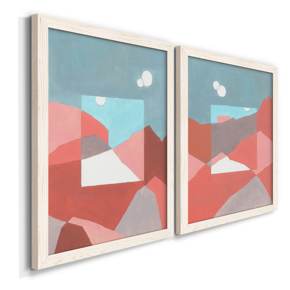 Angled view of a set of two white barnwood framed canvas prints featuring two modern abstract landscapes featuring layered red coral and turquoise desert-like geometry.