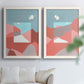 Set of two white barnwood framed canvas prints depicting faceted hills, warm horizons, and flat color planes arranged across two complementary compositions above a sofa in a bright living space.