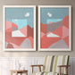 Set of two white barnwood framed canvas prints depicting two modern abstract landscapes featuring layered red coral and turquoise desert-like geometry above a sideboard in a cozy sitting room.