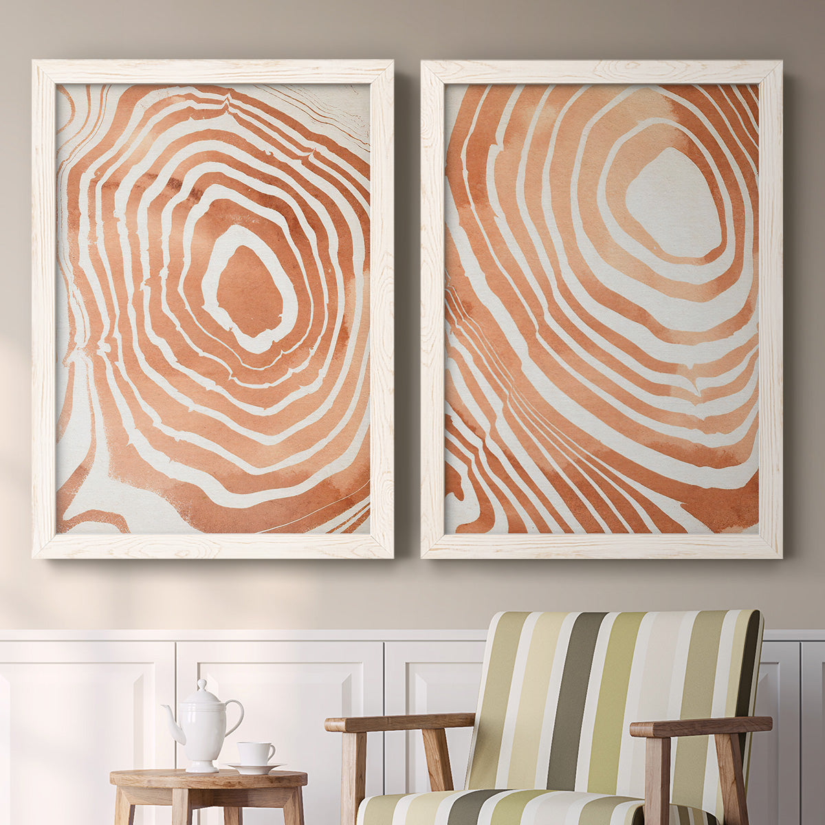 Set of two white barnwood framed canvas prints depicting two minimalist marbled pattern abstracts featuring concentric wood-grain rings and rippling contour lines above a sideboard in a cozy sitting room.