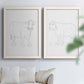Set of two white barnwood framed canvas prints depicting fine gray lines, white backgrounds, and quiet farm-animal profiles arranged across two complementary compositions above a sofa in a bright living space.