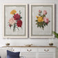 Set of two white barnwood framed canvas prints depicting a coordinated art pair of vintage mixed-flower bouquets on distressed paper rendered as traditional botanical collage prints above a dining room sideboard.