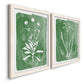 Angled view of a set of two white barnwood framed canvas prints featuring two rustic minimalist botanical studies featuring delicate wildflower and leafy stems.