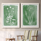 Set of two white barnwood framed canvas prints depicting two rustic minimalist botanical studies featuring delicate wildflower and leafy stems above a sideboard in a cozy sitting room.