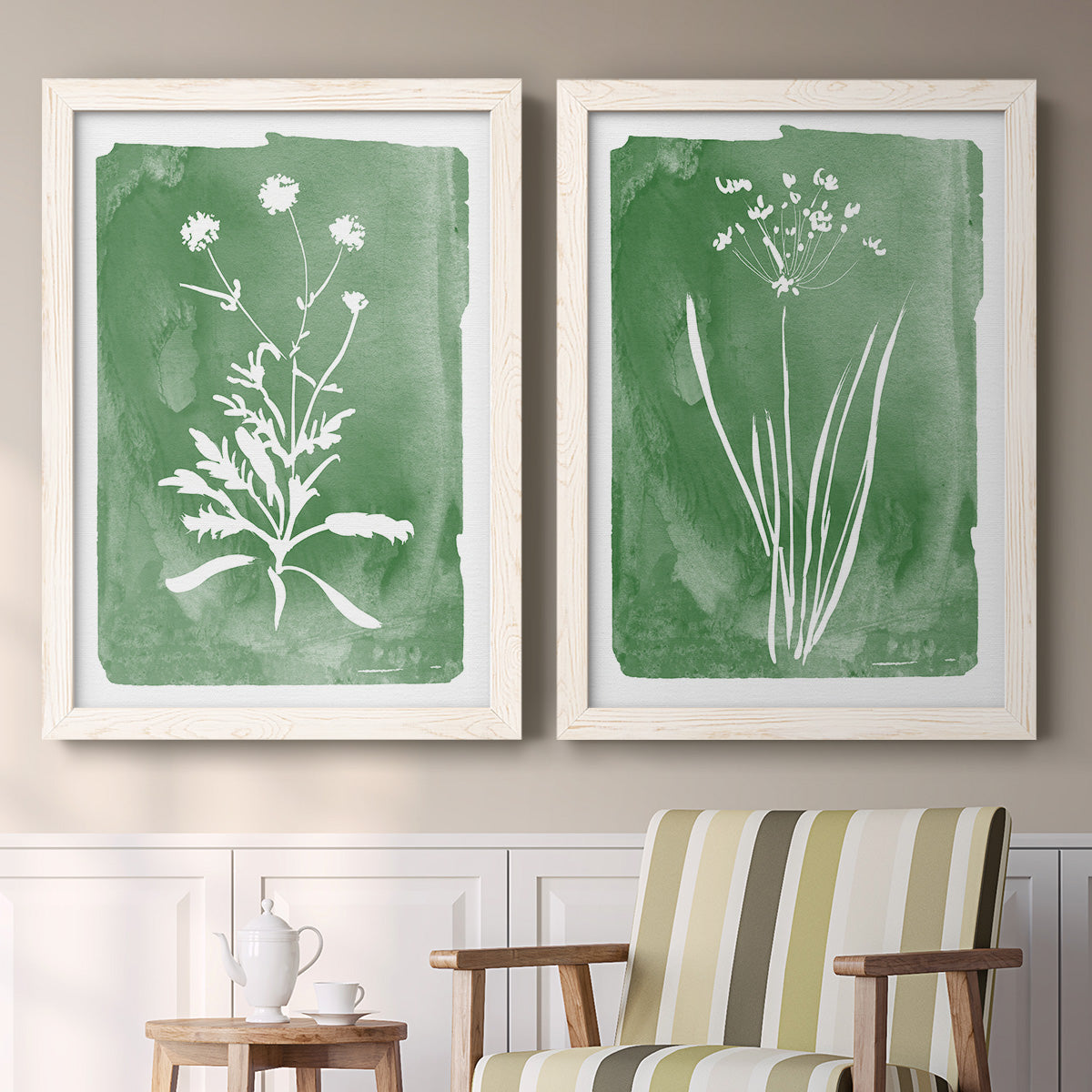 Set of two white barnwood framed canvas prints depicting two rustic minimalist botanical studies featuring delicate wildflower and leafy stems above a sideboard in a cozy sitting room.
