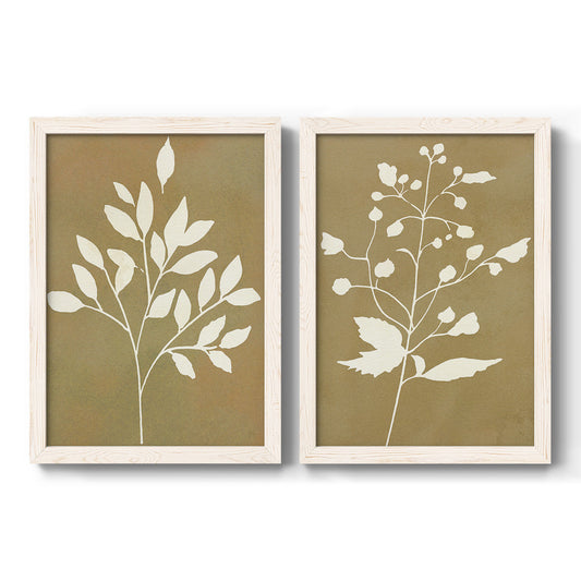 Set of two white barnwood framed canvas prints featuring two minimalist botanical silhouettes with white leafy stems against warm honey gold backgrounds.
