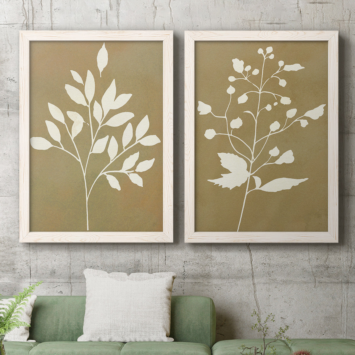 Set of two white barnwood framed canvas prints depicting a modern plant pair of cream branches berries and leaves on muted ochre fields above a sofa in a modern living room.