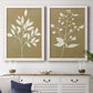 Set of two white barnwood framed canvas prints depicting a modern plant pair of cream branches berries and leaves on muted ochre fields above a dining room sideboard.