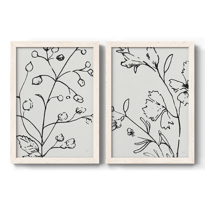 Set of two white barnwood framed canvas prints featuring two minimalist botanical line art featuring black contour drawings of leaves and flowers.