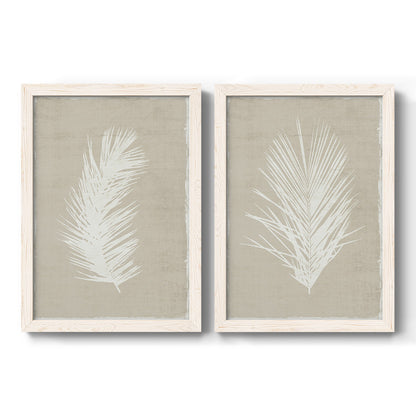 Set of two white barnwood framed canvas prints featuring two minimalist tropical botanical prints featuring white palm frond silhouettes.