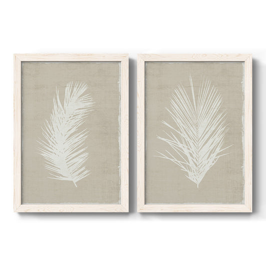 Set of two white barnwood framed canvas prints featuring two minimalist tropical botanical prints featuring white palm frond silhouettes.