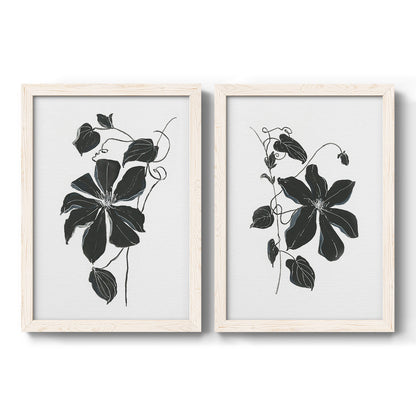 Set of two white barnwood framed canvas prints featuring two minimalist botanical prints featuring black leafy vine silhouettes.