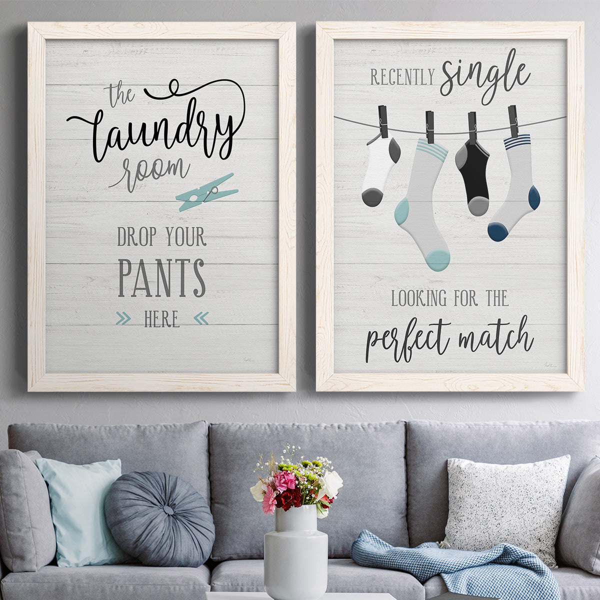 Set of two white barnwood framed canvas prints depicting paired rustic typographic wall art with hand-lettered phrases, socks hangers and laundry symbols on linen texture above a sofa in a contemporary living room.