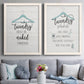 Set of two white barnwood framed canvas prints depicting paired rustic typographic wall art with hand-lettered phrases, socks hangers and laundry symbols on linen texture above a sofa in a contemporary living room.