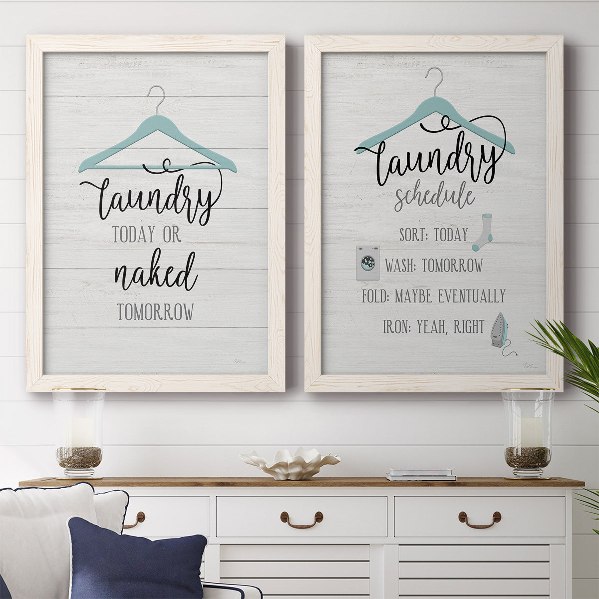 Set of two white barnwood framed canvas prints depicting a coordinated art pair of humorous laundry-room sayings and clothing icons rendered as rustic typographic wall art above a dining room sideboard.