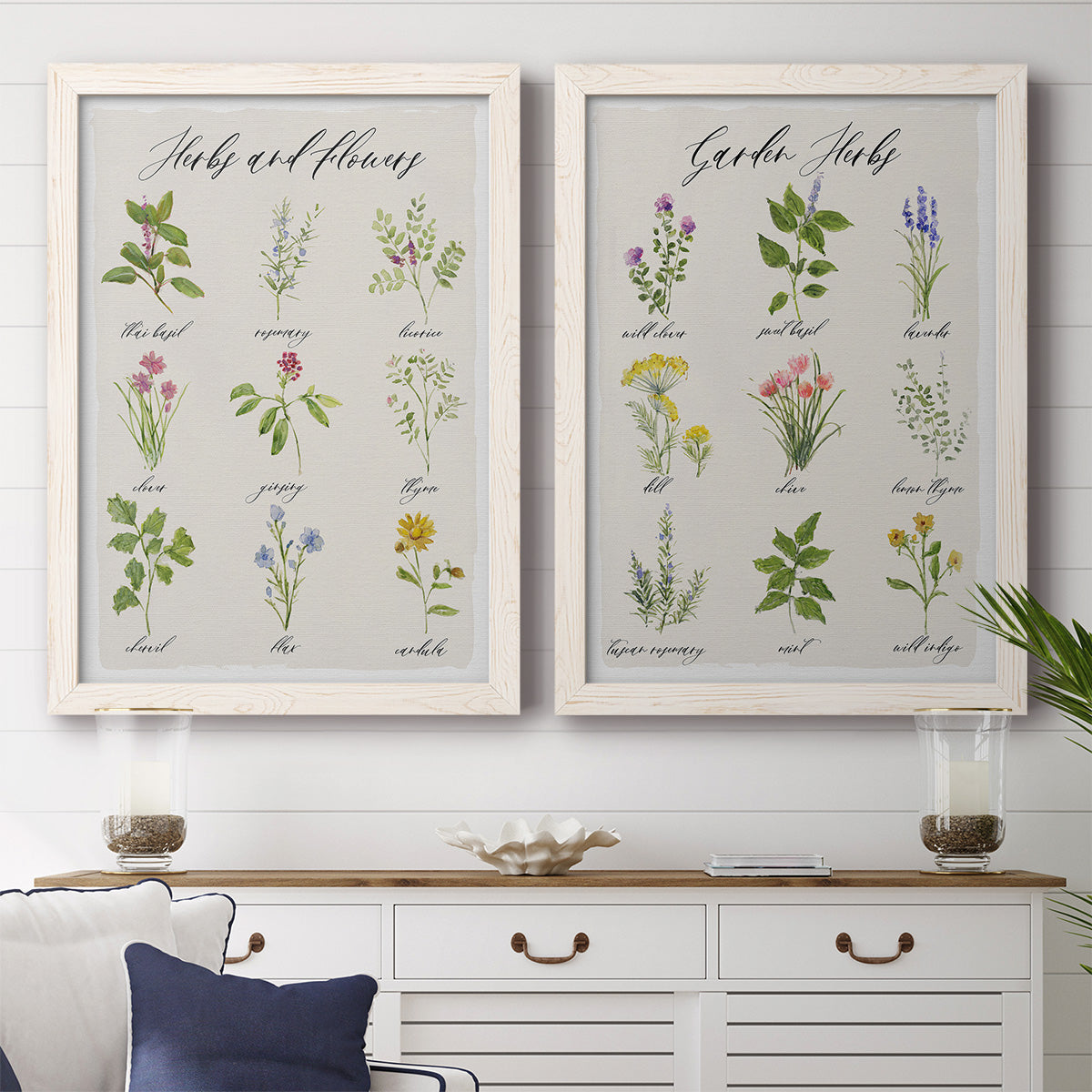 Set of two white barnwood framed canvas prints depicting a coordinated art pair of labeled collections of culinary herbs and wildflowers rendered as farmhouse botanical chart prints above a dining room sideboard.