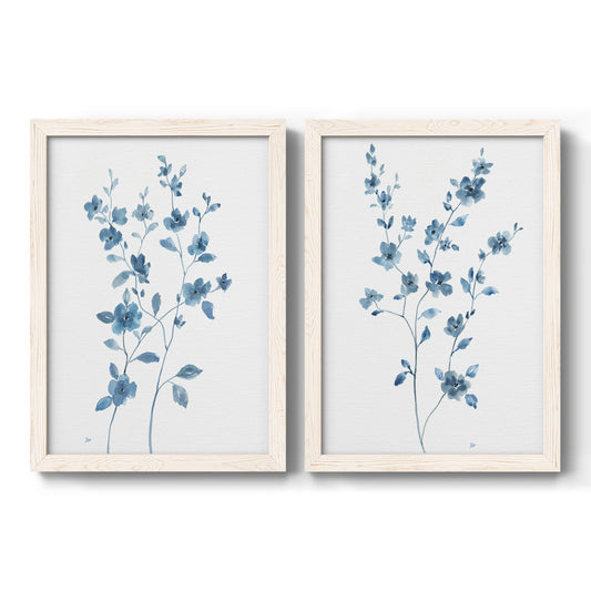 Set of two white barnwood framed canvas prints featuring two contemporary botanical paintings featuring blue watercolor flowers with fresh green leaves.