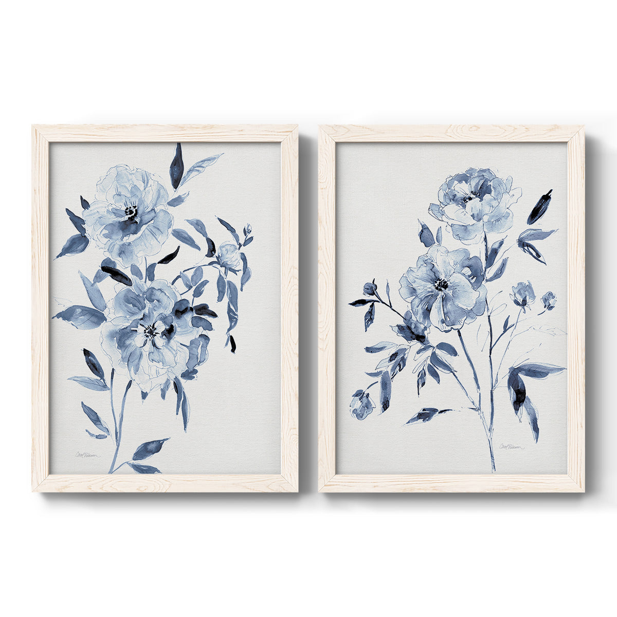 Set of two white barnwood framed canvas prints featuring two expressive watercolor botanical paintings featuring loose blue flowers and leafy branches.