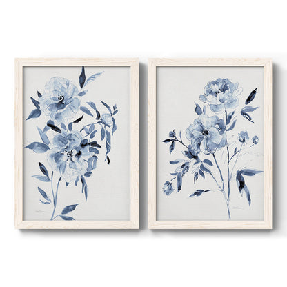 Set of two white barnwood framed canvas prints featuring two expressive watercolor botanical paintings featuring loose blue flowers and leafy branches.
