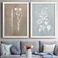 Set of two white barnwood framed canvas prints depicting paired rustic minimalist botanical prints with delicate stems, leaves, and blossoms against gray taupe and pale blue panels above a sofa in a contemporary living room.