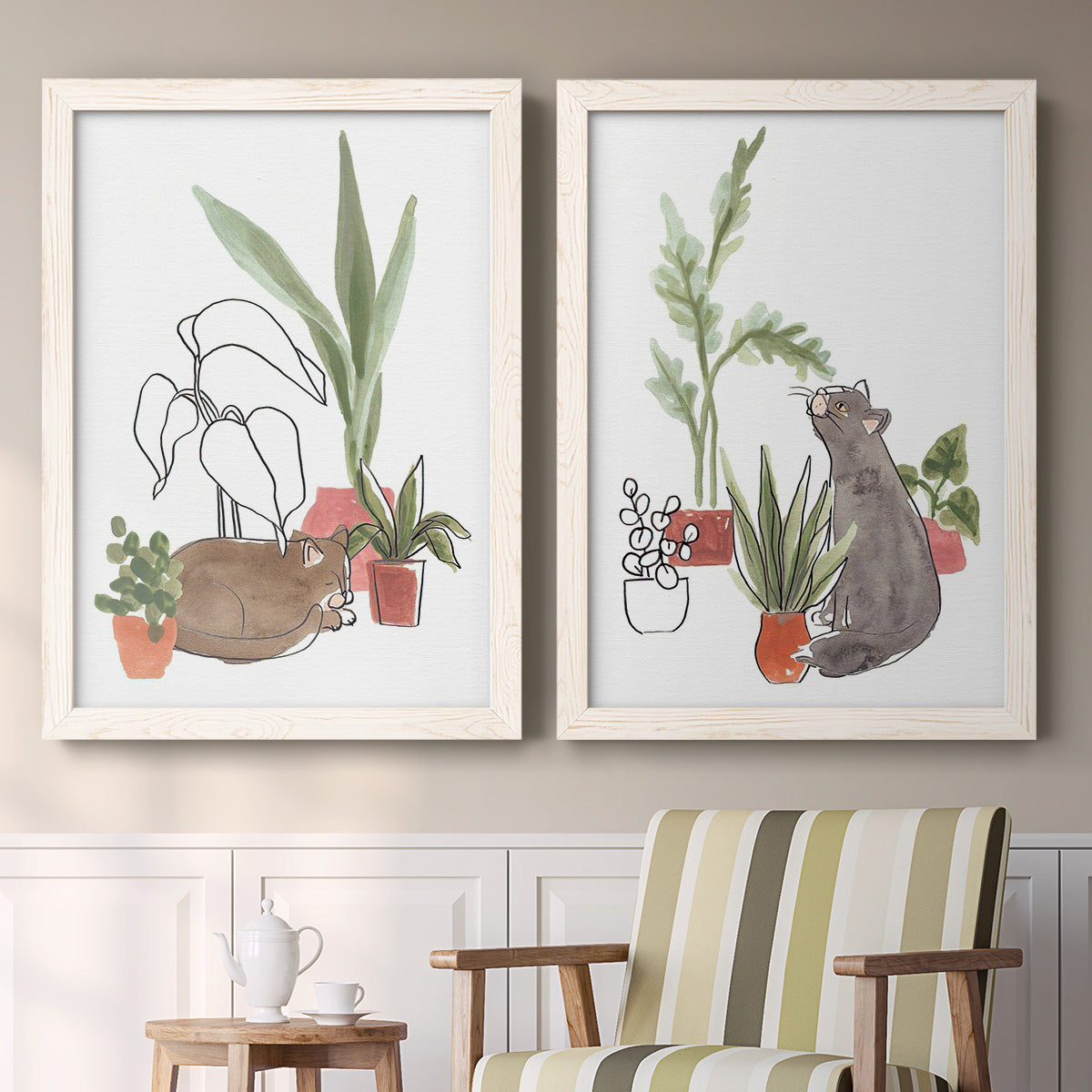 Set of two white barnwood framed canvas prints depicting two whimsical botanical animal illustrations featuring cats tucked among collections of potted houseplants above a sideboard in a cozy sitting room.