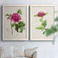 Set of two white barnwood framed canvas prints depicting peonies thistles leafy stems and archival cream paper arranged across two complementary compositions above a sofa in a bright living space.
