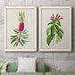 Set of two white barnwood framed canvas prints depicting a coordinated art pair of pink flowering plant specimens rendered as vintage botanical plate illustrations above a sofa in a modern living room.