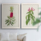 Set of two white barnwood framed canvas prints depicting peonies thistles leafy stems and archival cream paper arranged across two complementary compositions above a sofa in a bright living space.