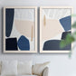 Set of two white barnwood framed canvas prints depicting rounded dark forms, pale sand fields, and clean modern edges arranged across two complementary compositions above a sofa in a bright living space.