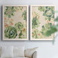 Set of two white barnwood framed canvas prints depicting green rosettes, peach blossoms, and mosaic-like outlines arranged across two complementary compositions above a sofa in a bright living space.