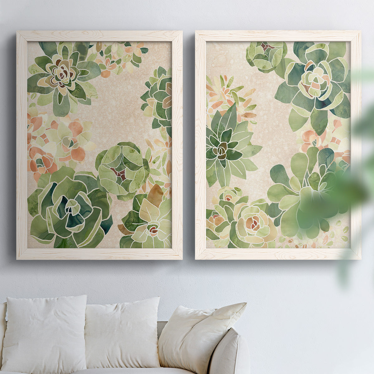 Set of two white barnwood framed canvas prints depicting green rosettes, peach blossoms, and mosaic-like outlines arranged across two complementary compositions above a sofa in a bright living space.