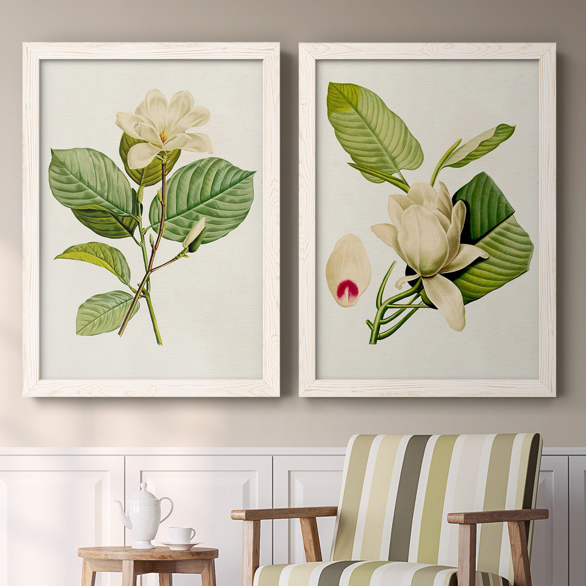 Set of two white barnwood framed canvas prints depicting two traditional botanical paintings featuring white magnolia blossoms and glossy green leaves above a sideboard in a cozy sitting room.