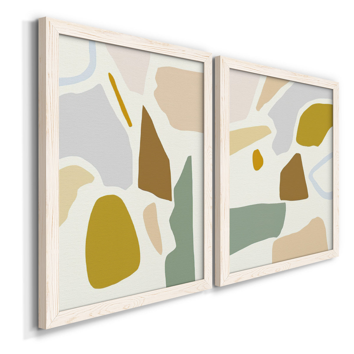 Angled view of a set of two white barnwood framed canvas prints featuring two pastel geometric abstracts featuring soft mustard sage gray and white irregular shapes.