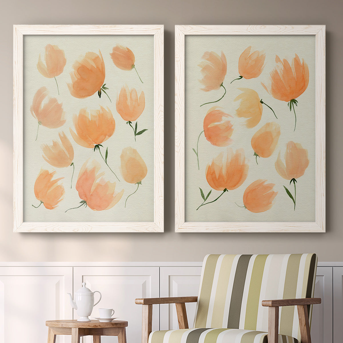 Set of two white barnwood framed canvas prints depicting two airy watercolor floral paintings featuring loose peach-orange tulip-like blossoms above a sideboard in a cozy sitting room.