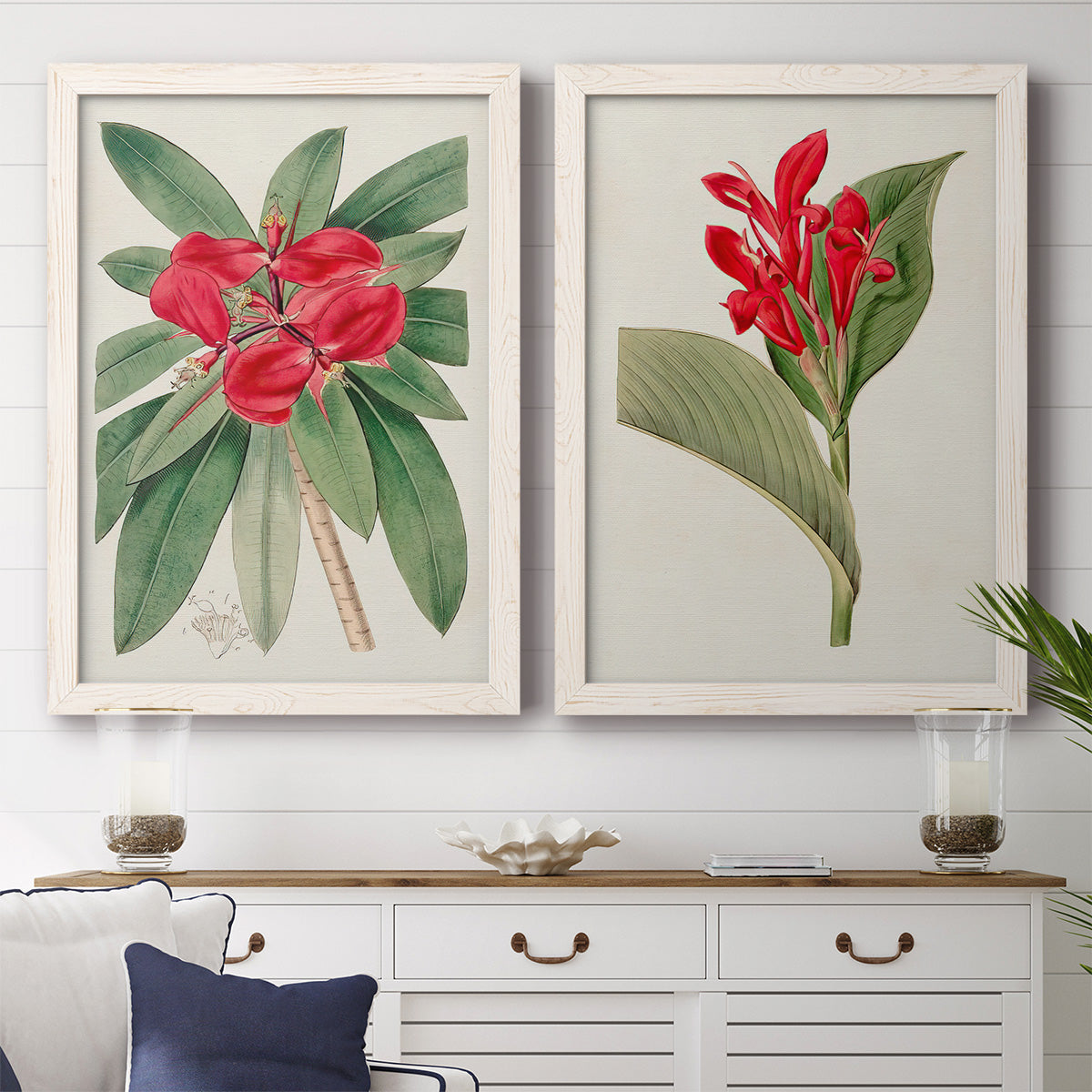 Set of two white barnwood framed canvas prints depicting a coordinated art pair of vivid tropical flowering plants rendered as antique botanical plate illustrations above a dining room sideboard.