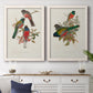 Set of two white barnwood framed canvas prints depicting a coordinated art pair of colorful tropical birds perched on leafy branches rendered as vintage ornithological illustrations above a dining room sideboard.
