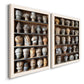 Angled view of a set of two white barnwood framed canvas prints featuring two fashion-object photography featuring shelves filled with wooden hat forms.