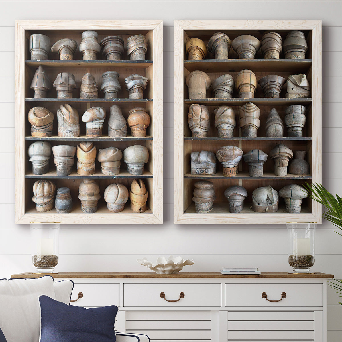 Set of two white barnwood framed canvas prints depicting a coordinated art pair of shelves filled with wooden hat forms rendered as fashion-object photography above a dining room sideboard.