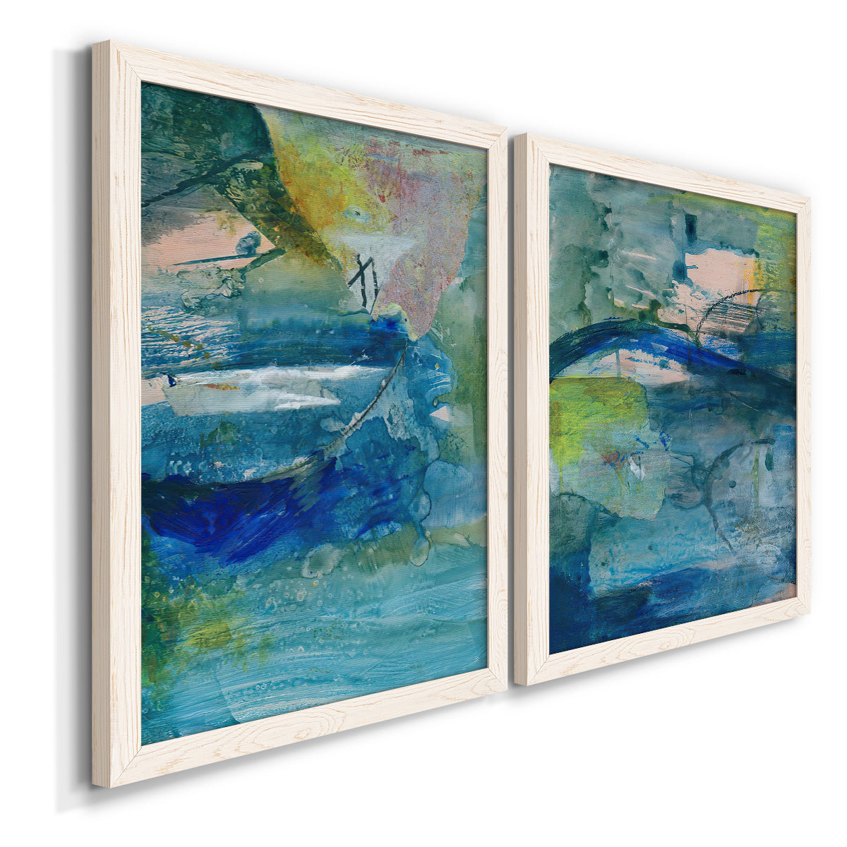 Angled view of a set of two white barnwood framed canvas prints featuring two energetic mixed-media abstracts featuring layered blue teal green and yellow painterly fields.