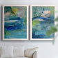 Set of two white barnwood framed canvas prints depicting broad strokes, scratched lines, and luminous color passages arranged across two complementary compositions above a sofa in a bright living space.
